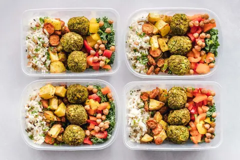 Cztery pojemniki z posiłkami: ryż, pieczone warzywa, falafel i sałatka. Idealne na dietę DASH przepisy.