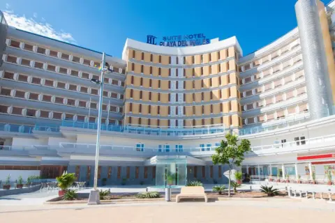 Nowoczesny hotel Suite Hotel Playa del Inglés z charakterystyczną, zakrzywioną fasadą i licznymi balkonami.