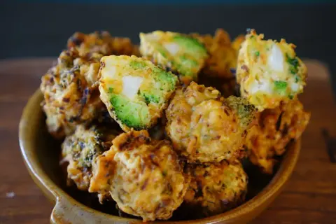Beignets de légumes croustillants, un délice doré avec des morceaux de brocoli et de pomme de terre bien visibles.