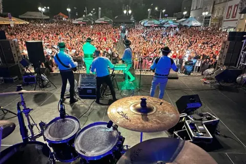 Baciary członkowie zespołu grają na scenie dla tłumu fanów.