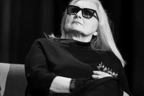 Magda Umer w okularach, z długimi blond włosami, siedzi z rękami skrzyżowanymi na piersi. Jej piosenki magdy umer alfabetycznie mogłyby być tematem tej rozmowy.