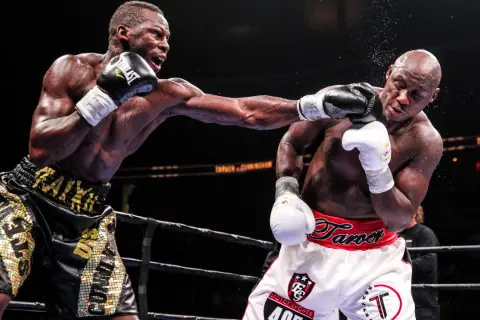 Two boxers exchange blows in the ring. The boxer on the left lands a punch, while the boxer on the right braces for impact. This intense fight showcases the power and skill involved in boxing, where weight classes like cruiserweight define the competit...