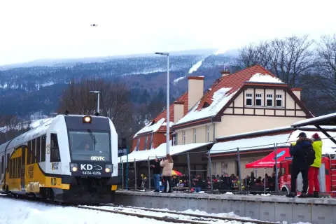 Pociąg KD na stacji w Świeradowie-Zdroju. Jak dojechać PKP? Zimą widok na ośnieżone góry i budynek dworca.