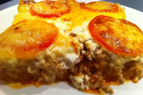 En saftig tacopaj i långpanna med köttfärs, ost och tomatskivor. Perfekt för hela familjen!
