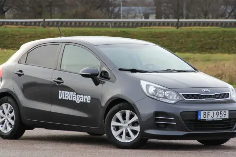 Mörkgrå Kia Rio med texten "ViBilägare" på sidan. En bil som kan ha ett kia rio problem.