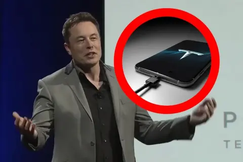 Elon Musk prezentuje telefon z logo Tesli, podłączony do ładowania.
