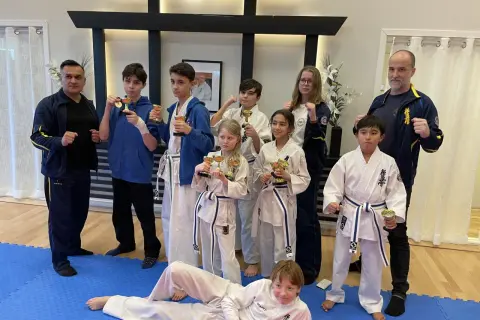 Stolta barn med pokaler efter träning i Oyama Karate Kai. Tränare och elever firar framgångar.