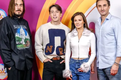 Cztery osoby, w tym muzyczna jury, pozują do zdjęcia na tle kolorowej ścianki.