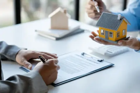 Firma di un contratto di comodato d'uso oneroso con una casa modello in mano.