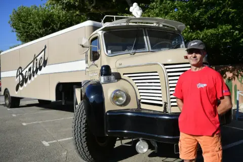 Un homme pose devant un camion Berthelot, un camion année 50 restauré avec soin.