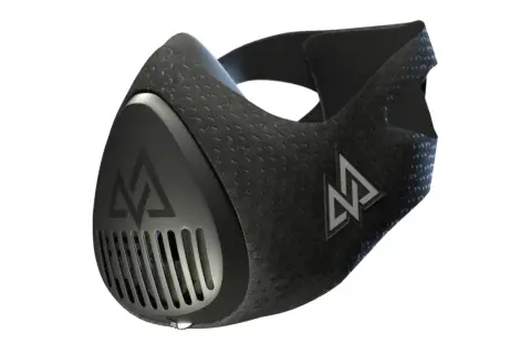 A black high elevation mask with a textured surface and a silver logo. It features a vented front and adjustable straps.
