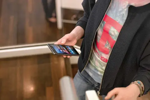 Osoba trzyma telefon Samsung, na ekranie widać ikony aplikacji. Może właśnie robi nagrywanie ekranu Samsung.