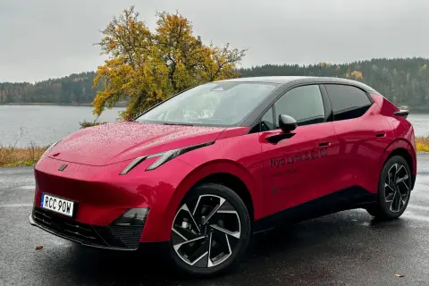Röd elbil parkerad vid en sjö med höstfärger. En perfekt plats för en tco kalkyl.