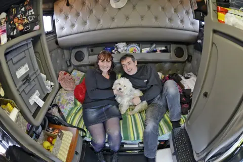 Un couple et leur chien blanc profitent d'un moment de détente dans l'espace cosy de leur camion américain.