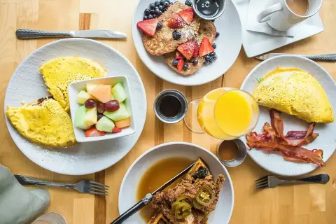 Pyszne śniadanie: omlety, naleśniki z owocami, gofry z kurczakiem i bekonem. Idealny wybór na **half board**.