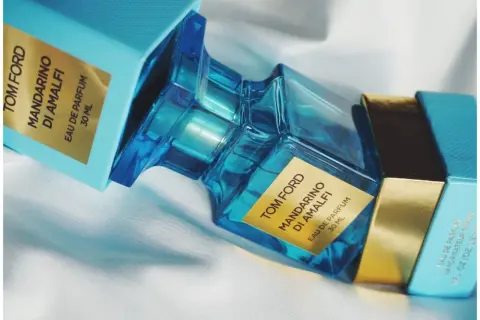 Błękitne pudełko i szklana butelka perfum Tom Ford Mandarino di Amalfi, emanujące świeżością włoskiego wybrzeża.
