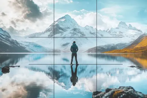 Un homme contemplant un paysage de montagne enneigée et un lac reflétant le ciel. Une composition photographique parfaite.