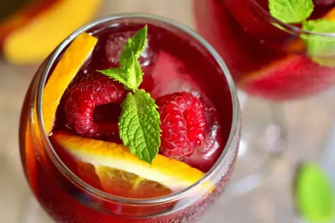 Orzeźwiająca sangria co to? Pyszny napój z malinami, pomarańczą i miętą, idealny na upalne dni.