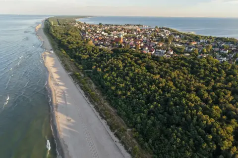 Plaża i las na Pomorzu, ukryte perełki, które warto odkryć. Widok z lotu ptaka na wybrzeże i urokliwe miasteczko.