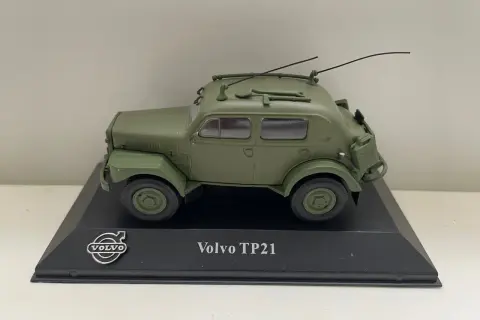Modell av en grön Volvo TP21 "Sugga" med antenner och takräcke, monterad på en svart piedestal.