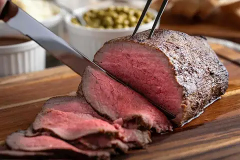 Roast beef succulento affettato, pronto per essere gustato. Una perfetta roast beef ricetta in pentola per un pranzo speciale.