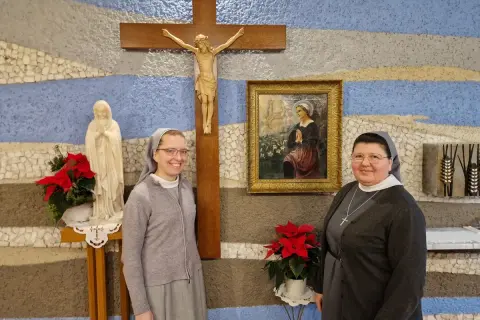 Dwie zakonnice pozują do zdjęcia przy krzyżu i figurze Matki Bożej. 27 stycznia to ważna data dla ich zgromadzenia.