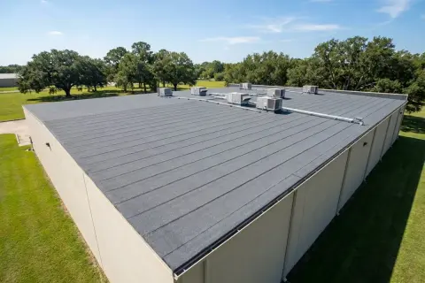 A commercial building with a durable SBS roofing system, featuring multiple HVAC units on its flat, grey surface.