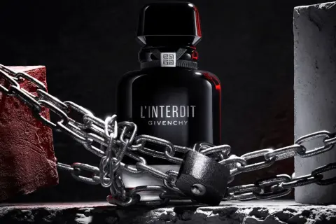 L'Interdit Intense Givenchy, zamknięty w łańcuchach i kłódce, symbolizuje zakazaną, intensywną moc zapachu.