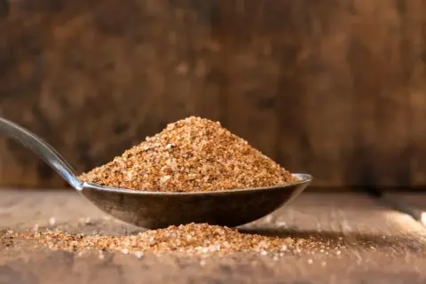 Łyżka pełna aromatycznej przyprawy cajun, gotowa do nadania potrawom południowego charakteru.