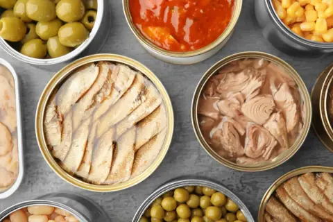 Vielfalt an Konserven: Oliven, Sauce, Mais, Fisch und Bohnen – alles **processor food** für schnelle Mahlzeiten.