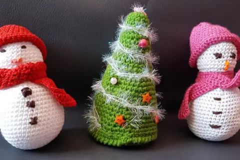 Trois adorables bonhommes de neige et un sapin de Noël tricotés, parfaits pour une déco de Noël. Modèle gratuit déco noël au tricot.