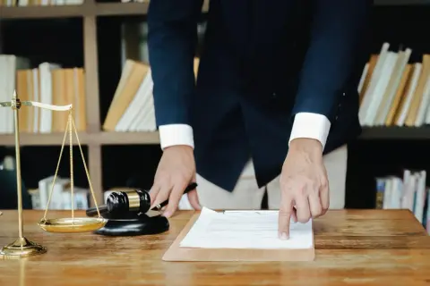Prawnik wyjaśnia, jak wyliczyć podatek od spadku. Przykład na dokumencie, obok wagi sprawiedliwości i młotka.