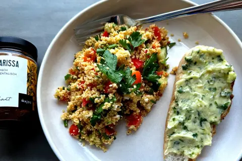 Frischer Couscous-Salat mit Tomaten, Gurken und Kräutern, serviert mit Kräuterbutterbrot. Ein tolles Couscous-Salat-Rezept für den Sommer.