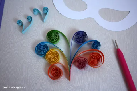 Creazione di maschere carnevale fai da te bambini con strisce colorate in quilling. Un progetto creativo per decorare.