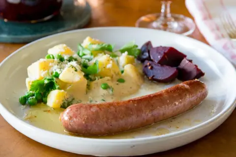 En tallrik med stekt isterband, potatis med ärtor och dill, samt rödbetor. Ett klassiskt svenskt recept som passar perfekt till helgen.