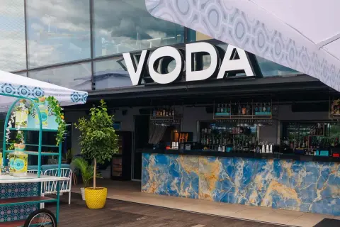 Warszawa knajpy z klimatem: bar VODA z niebieskim marmurowym blatem i butelkami ginu na wózku.