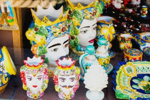 Ceramiche siciliane con teste di moro, vasi decorati e piatti colorati, un'esplosione di arte che ricorda il fascino di Palermo.