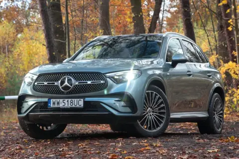 Szary Mercedes GLC 300 4Matic na tle jesiennego lasu.