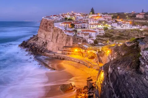 En pittoresk kuststad i Portugal, med vita hus på klipporna och en strand nedanför. Ett perfekt portugal resmål.