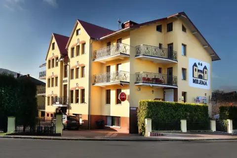 Żółty budynek hotelu Milena w Milówce z balkonami i logo hotelu.
