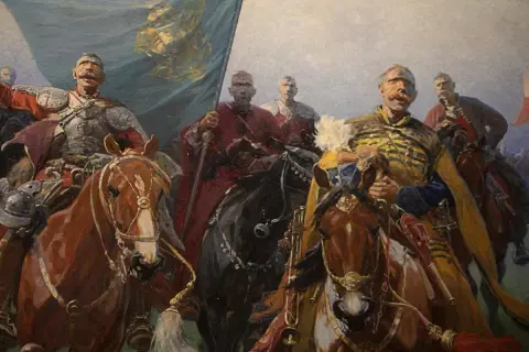 Józef Brandt obrazy: husaria na koniach, z chorągwią i w zbrojach, gotowa do walki. Dynamiczna scena historyczna.