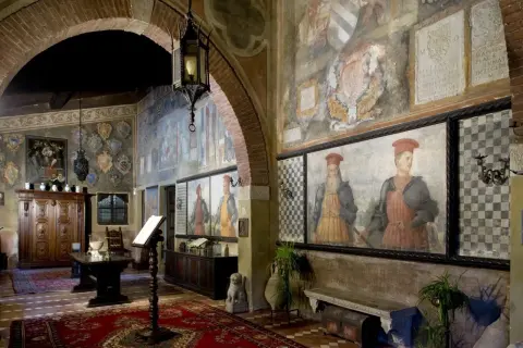 Interno del castello di Drugolo con affreschi storici, ritratti di nobili e arredi antichi.