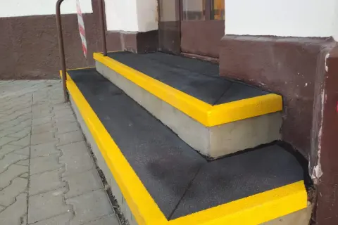Nowe, antypoślizgowe nakładki na schody betonowe z żółtymi obrzeżami zapewniają bezpieczeństwo.