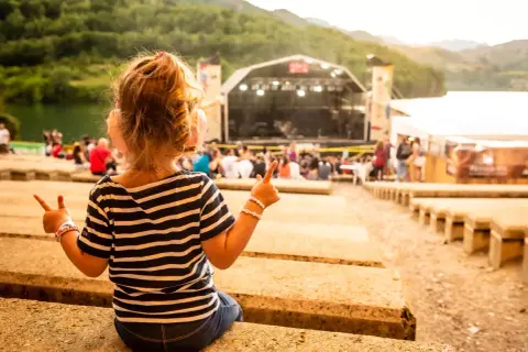Niña emocionada en el concierto ZAZ Pirineos Sur, disfrutando la música al aire libre.