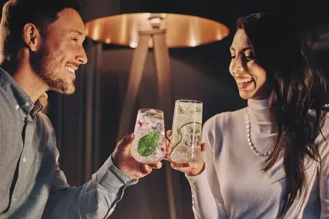 Para wznosi toast drinkami, szukając inspiracji na białystok atrakcje dla par.
