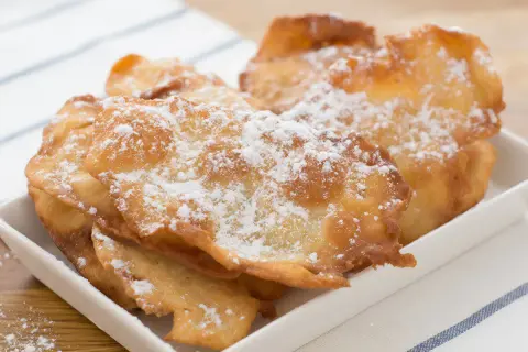 Orejas de carnaval receta gallega, crujientes y espolvoreadas con azúcar glas, listas para disfrutar.