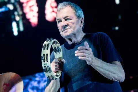 Ian Gillan, wokalista Deep Purple, gra na tamburynie podczas koncertu.