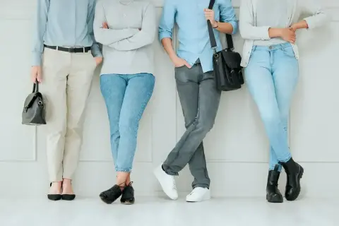 Cztery osoby w casualowych stylizacjach, każdy prezentuje swój ootd. Jasne jeansy, beżowe spodnie i szare dżinsy.
