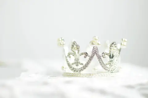 Srebrna korona ozdobiona perłami i kryształkami. Symbolizuje siłę, władzę i piękno, często wybierana jako tatuaż korona znaczenie.