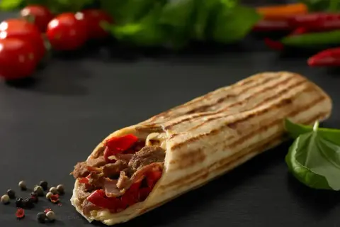 Pyszny kebab z mięsem i papryką, idealny na szybki posiłek. Zastanawiasz się, ile kosztuje kebab?